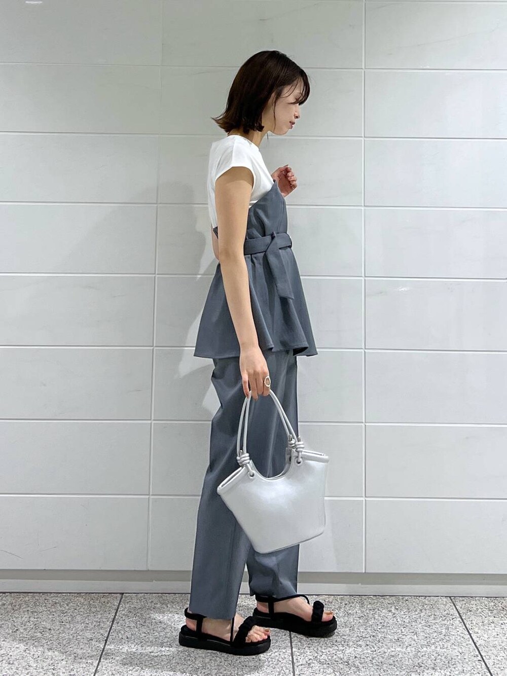 ブラック系のサンダル、シルバー系のハンドバッグ、ブルー系のその他パンツを着用したレディースの夏コーディネートの2枚目の写真