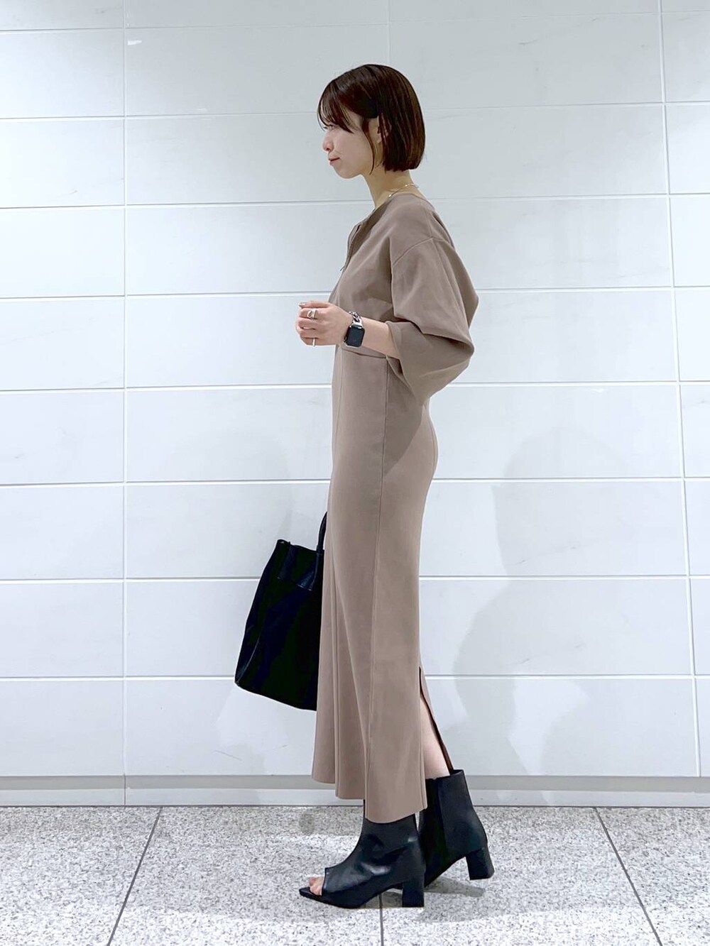 ブラック系のトートバッグ、ブラウン系のワンピース、ブラック系のブーツを着用したレディースの冬コーディネートの2枚目の写真