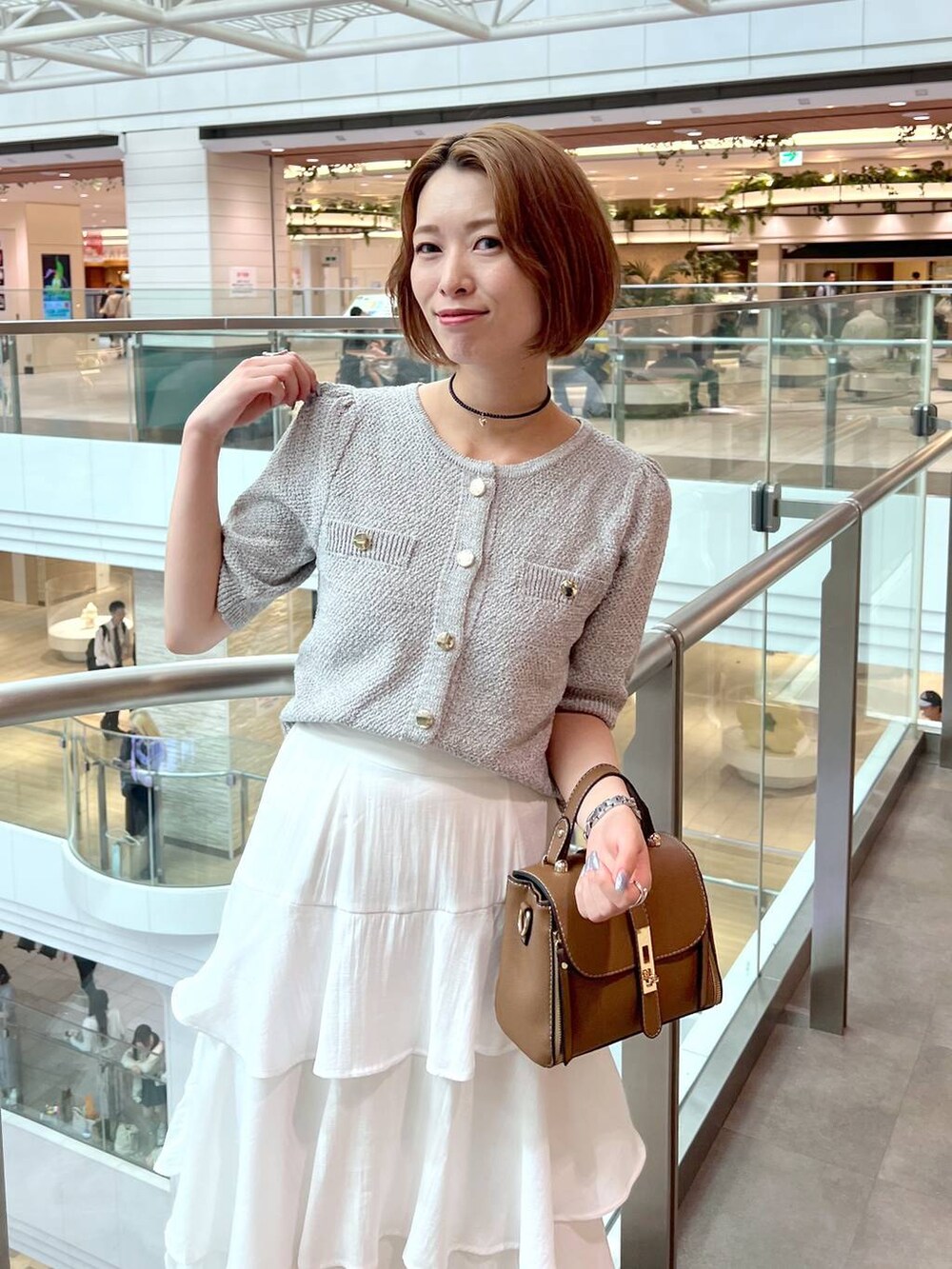 ホワイト系のサンダル、ホワイト系のスカート、ブラウン系のショルダーバッグを着用したレディースの夏コーディネートの5枚目の写真