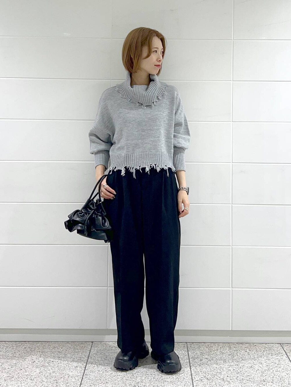 ブラック系のブーツ、ブラック系のショルダーバッグ、ホワイト系のその他アウターを着用したレディースの秋コーディネートの4枚目の写真