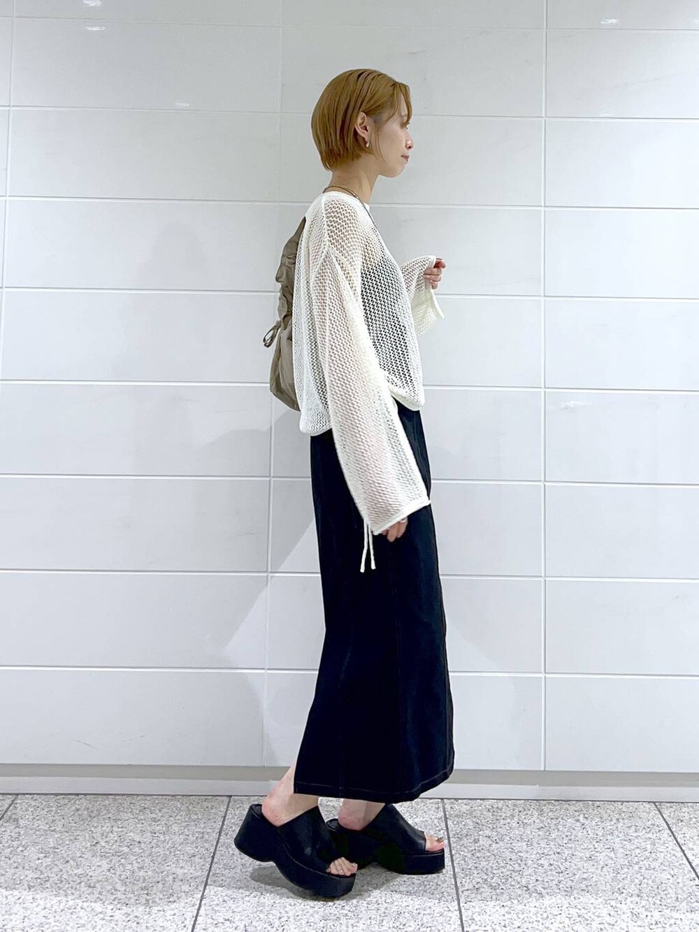 ブラック系のサンダル、ブラック系のキャミソール、ホワイト系のニット/セーターを着用したレディースの夏コーディネートの2枚目の写真