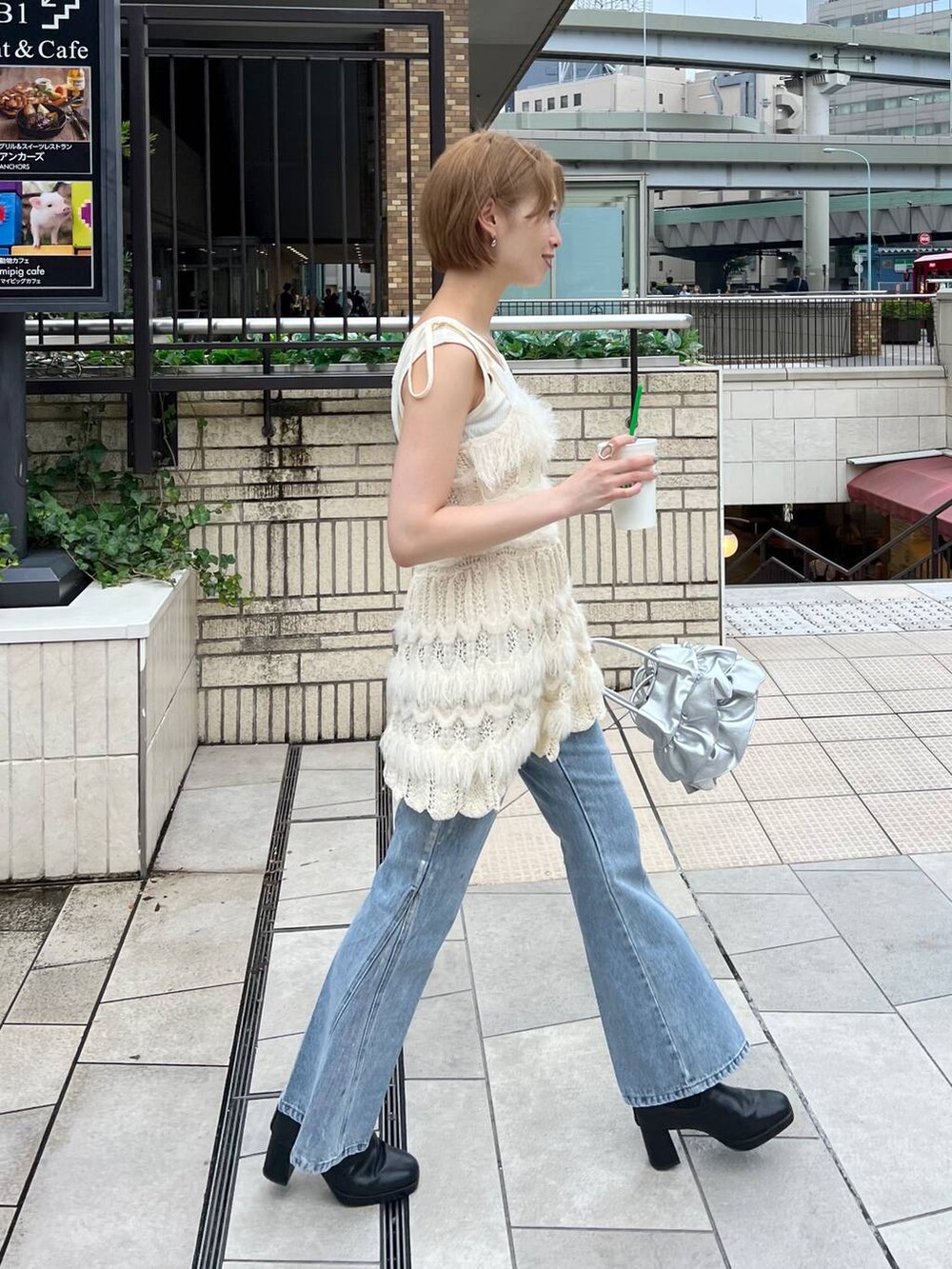 ブルー系のデニムパンツ、ホワイト系のキャミソール、ホワイト系のニット/セーターを着用したレディースの秋コーディネートの7枚目の写真