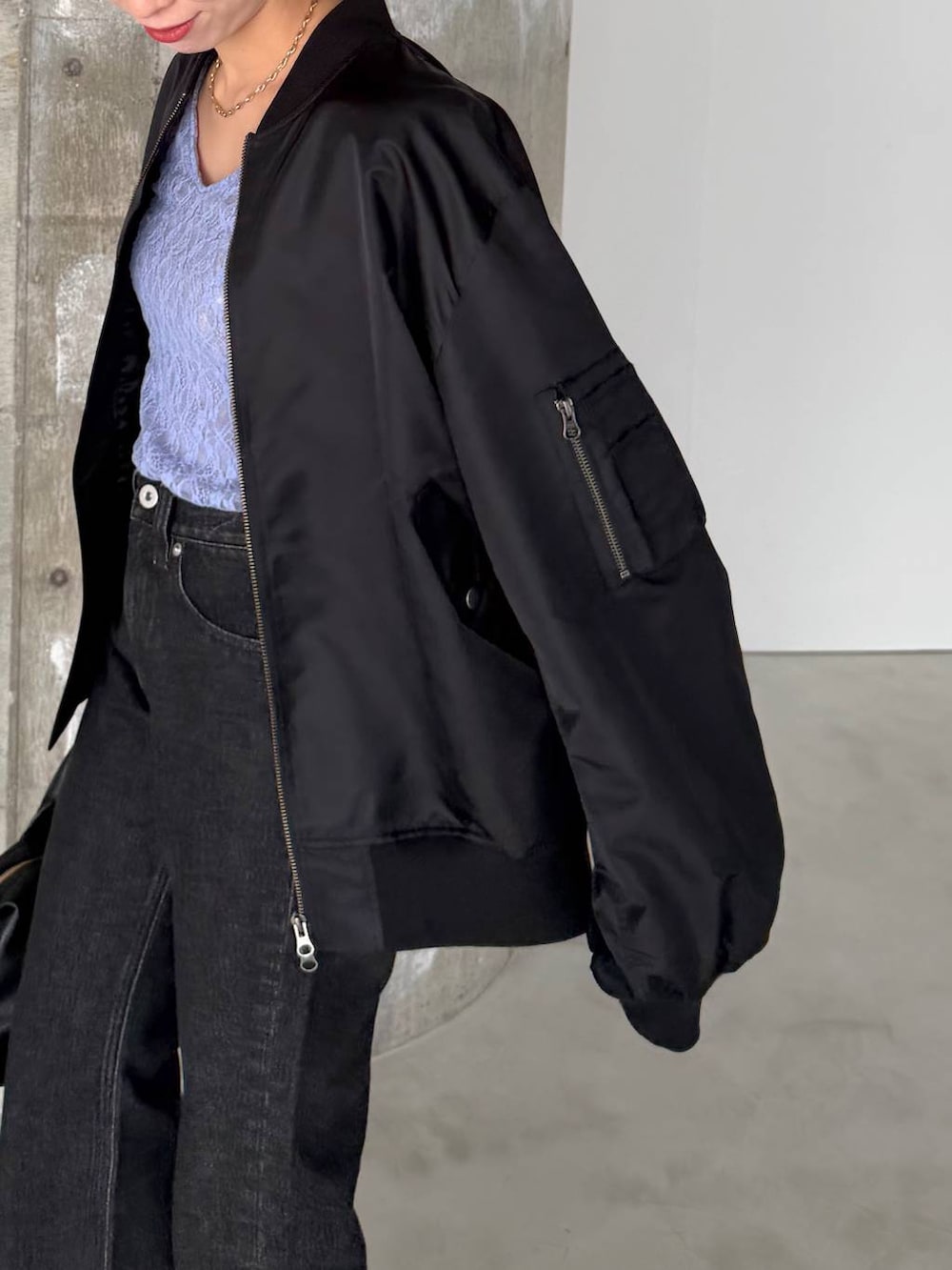 ブラック系のボストンバッグ、ブラック系のデニムパンツ、ブラック系のサンダルを着用したレディースの冬コーディネートの4枚目の写真