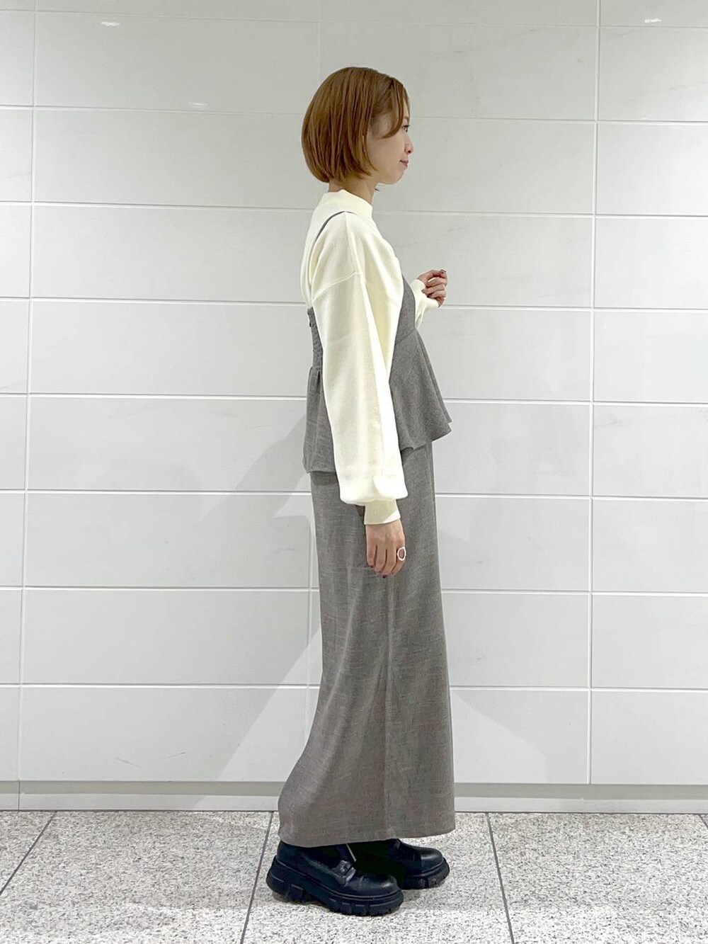 ブラック系のショルダーバッグ、ブラック系のブーツ、ブラウン系のワンピースを着用したレディースの秋コーディネートの5枚目の写真