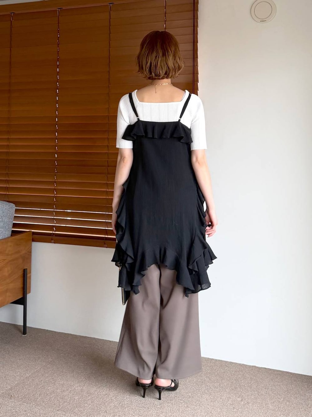 ブラック系のサンダル、ブラック系のショルダーバッグ、ブラック系のチュニックを着用したレディースの春コーディネートの3枚目の写真