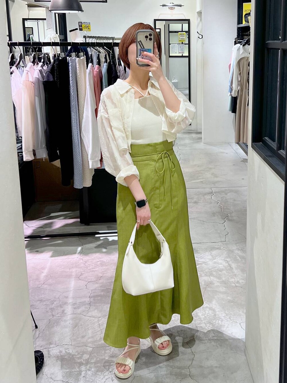 ホワイト系のタンクトップ、グリーン系のスカート、ホワイト系のワンピースを着用したレディースの春コーディネートの4枚目の写真