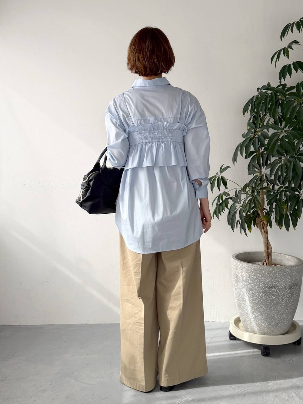 ブラック系のボストンバッグ、ブルー系のシャツ/ブラウス、ベージュ系のチノパンツを着用したレディースの春コーディネートの3枚目の写真