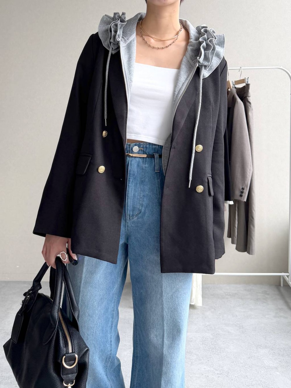 ブルー系のデニムパンツ、グレー系のパーカー、ブラック系のボストンバッグを着用したレディースの秋コーディネートの4枚目の写真