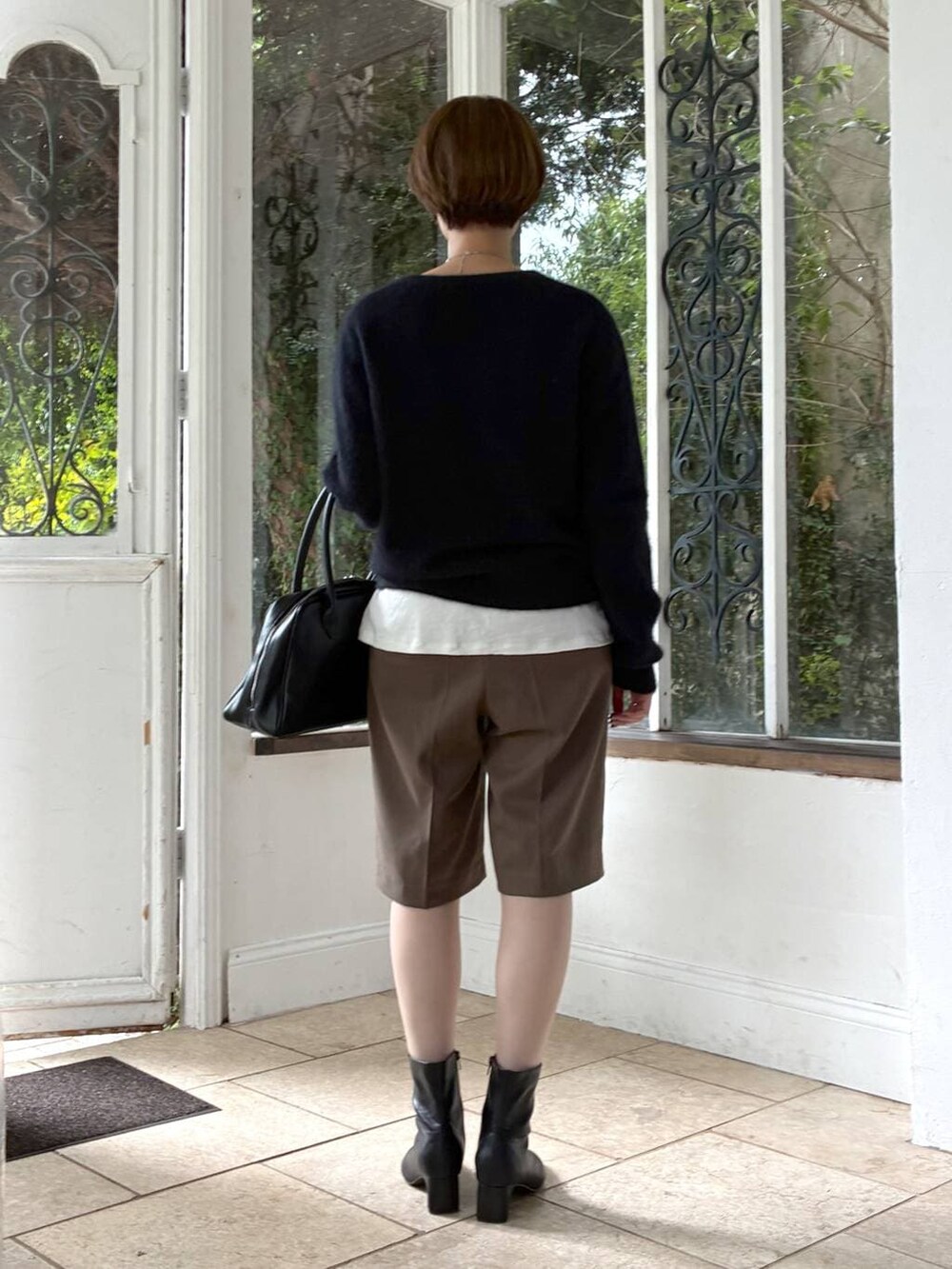 ホワイト系のTシャツ/カットソー、ブラック系のブーツ、ブラック系のトートバッグを着用したレディースの秋コーディネートの3枚目の写真