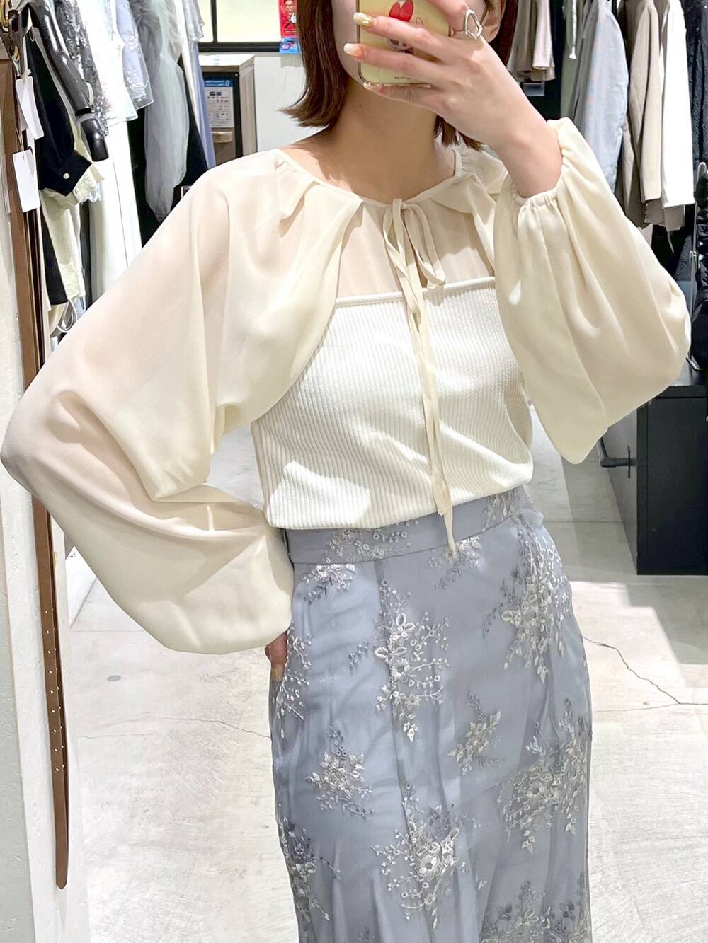 ブルー系のスカート、ホワイト系のTシャツ/カットソー、ホワイト系のサンダルを着用したレディースの春コーディネートの4枚目の写真