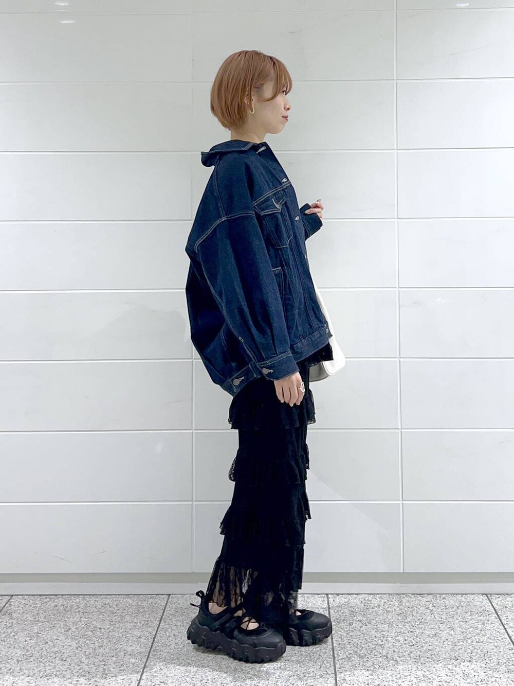 ホワイト系のトートバッグ、ブルー系のデニムジャケット、ブラック系のバレエシューズを着用したレディースの春コーディネートの2枚目の写真