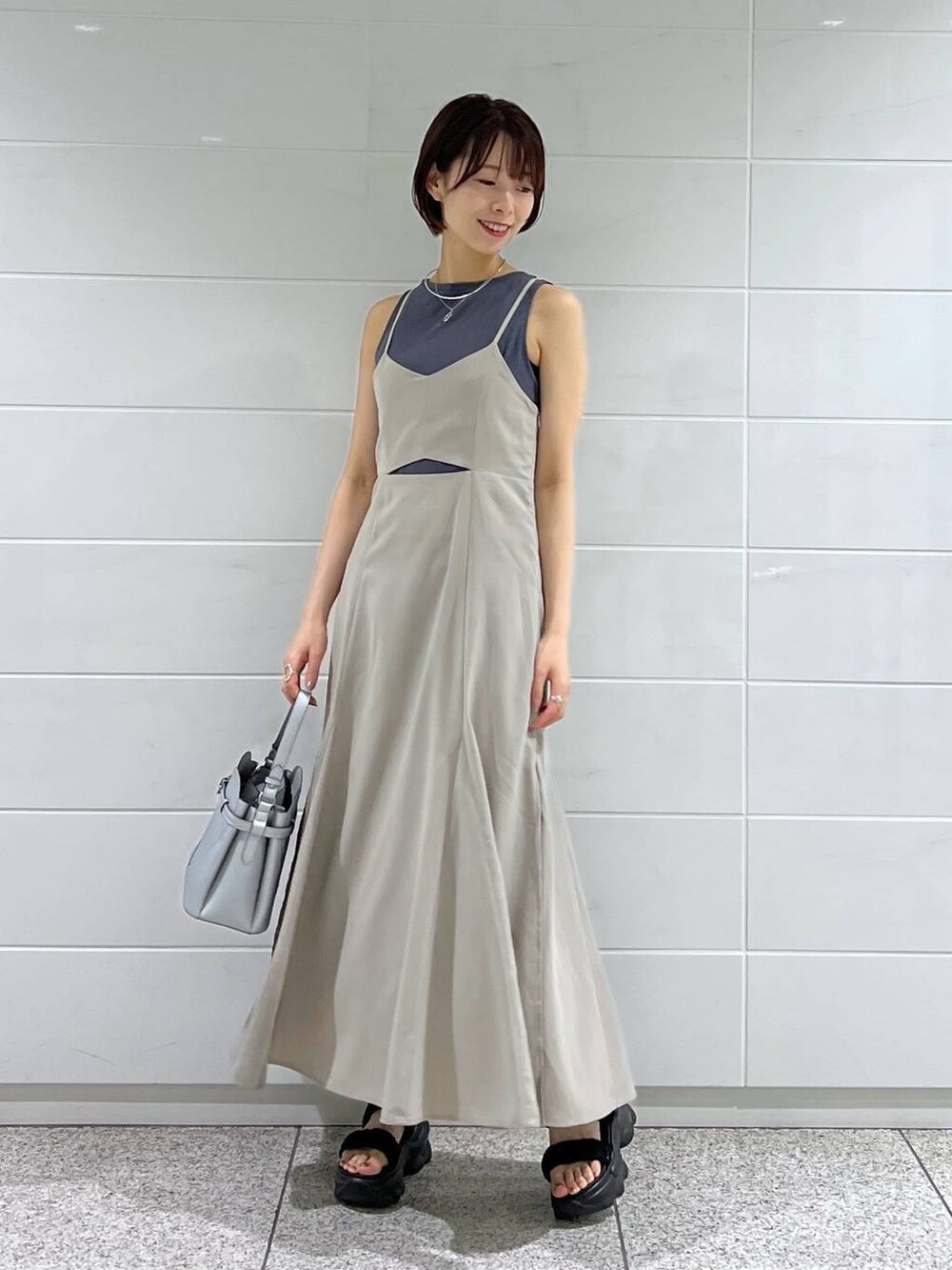 ブラック系のブルゾン、シルバー系のショルダーバッグ、ベージュ系のワンピースを着用したレディースの夏コーディネートの4枚目の写真