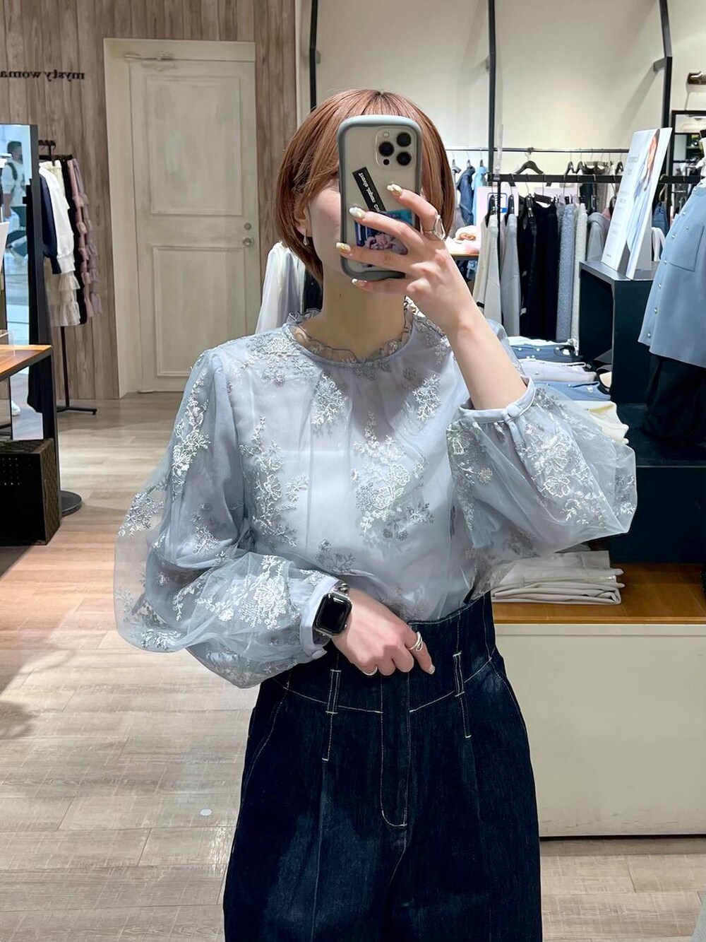 ホワイト系のショルダーバッグ、シルバー系のバレエシューズ、ブルー系のデニムパンツを着用したレディースの春コーディネートの4枚目の写真