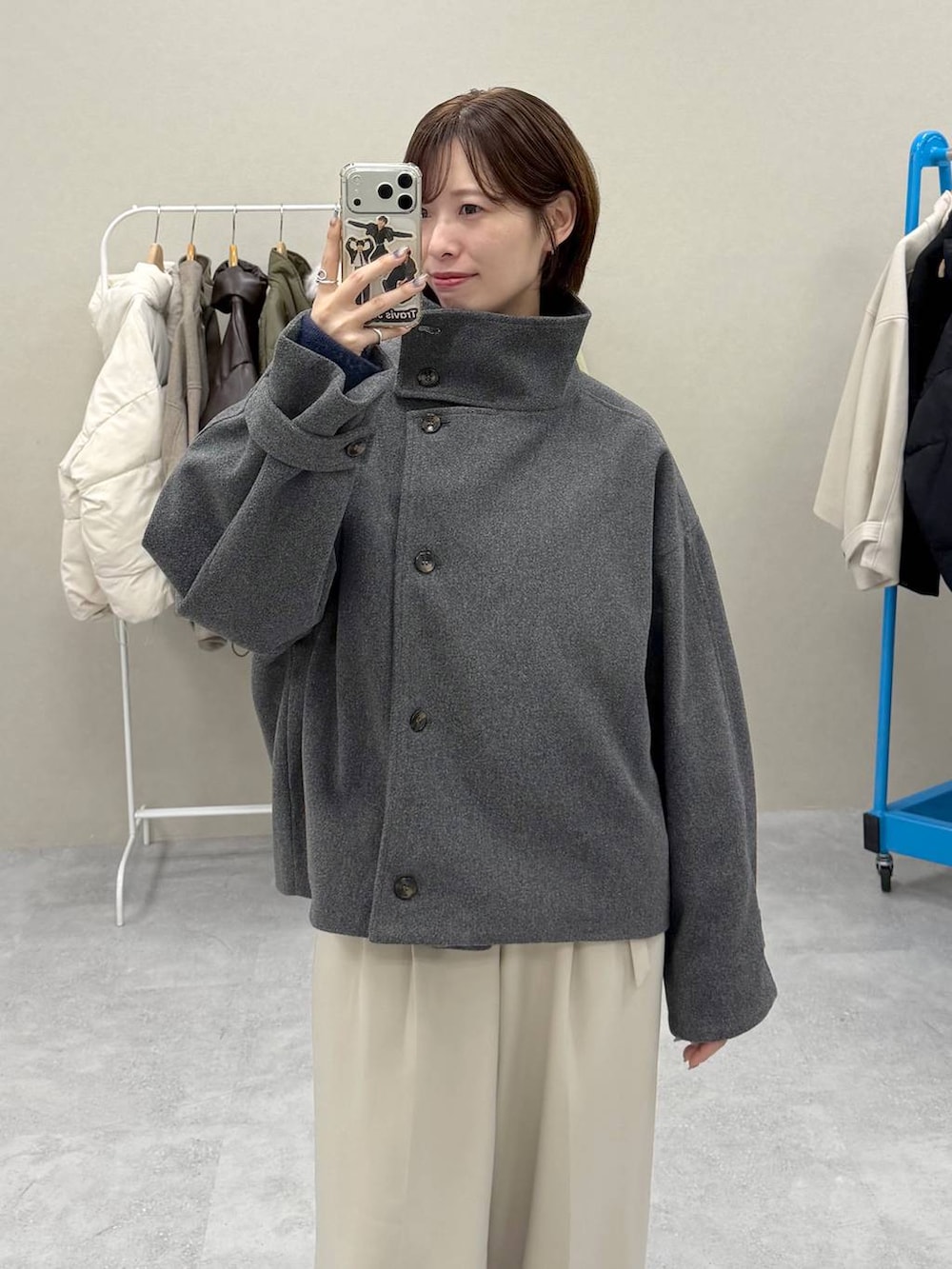 グレー系のトレンチコート、ベージュ系のスラックスを着用したレディースの秋コーディネートの2枚目の写真