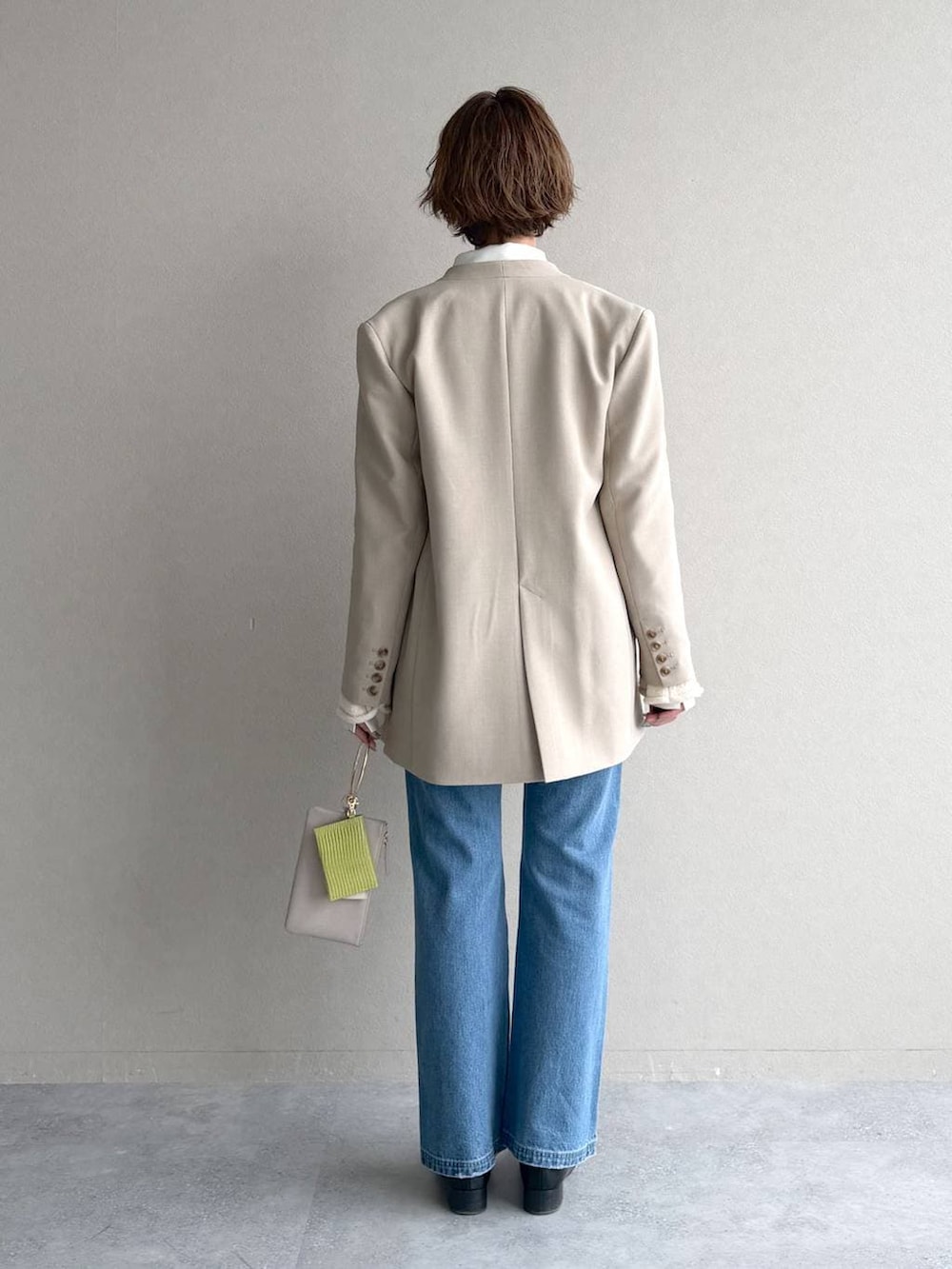 ブラック系のローファー、ブルー系のデニムパンツ、ベージュ系のテーラードジャケットを着用したレディースの冬コーディネートの3枚目の写真