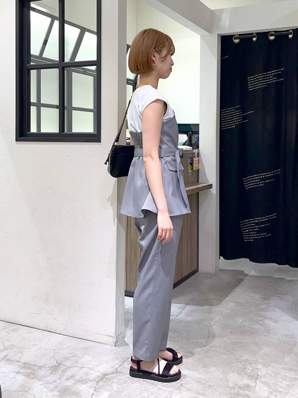 ブラック系のサンダル、グレー系のその他パンツ、グレー系のTシャツ/カットソーを着用したレディースの春コーディネートの2枚目の写真