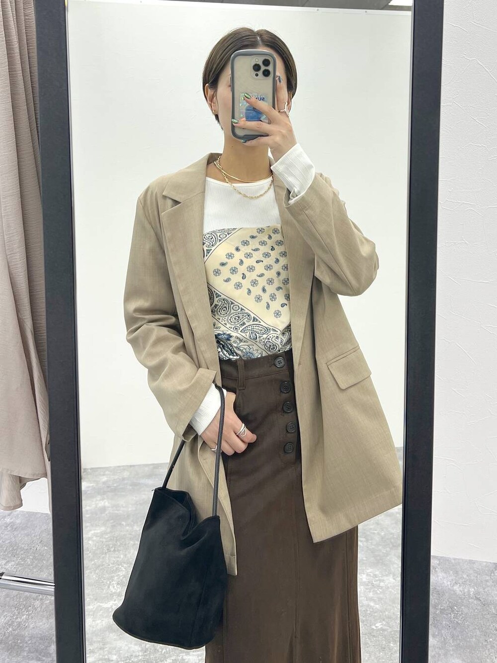 ベージュ系のテーラードジャケット、ホワイト系のTシャツ/カットソー、ブラウン系のスカートを着用したレディースの秋コーディネートの5枚目の写真
