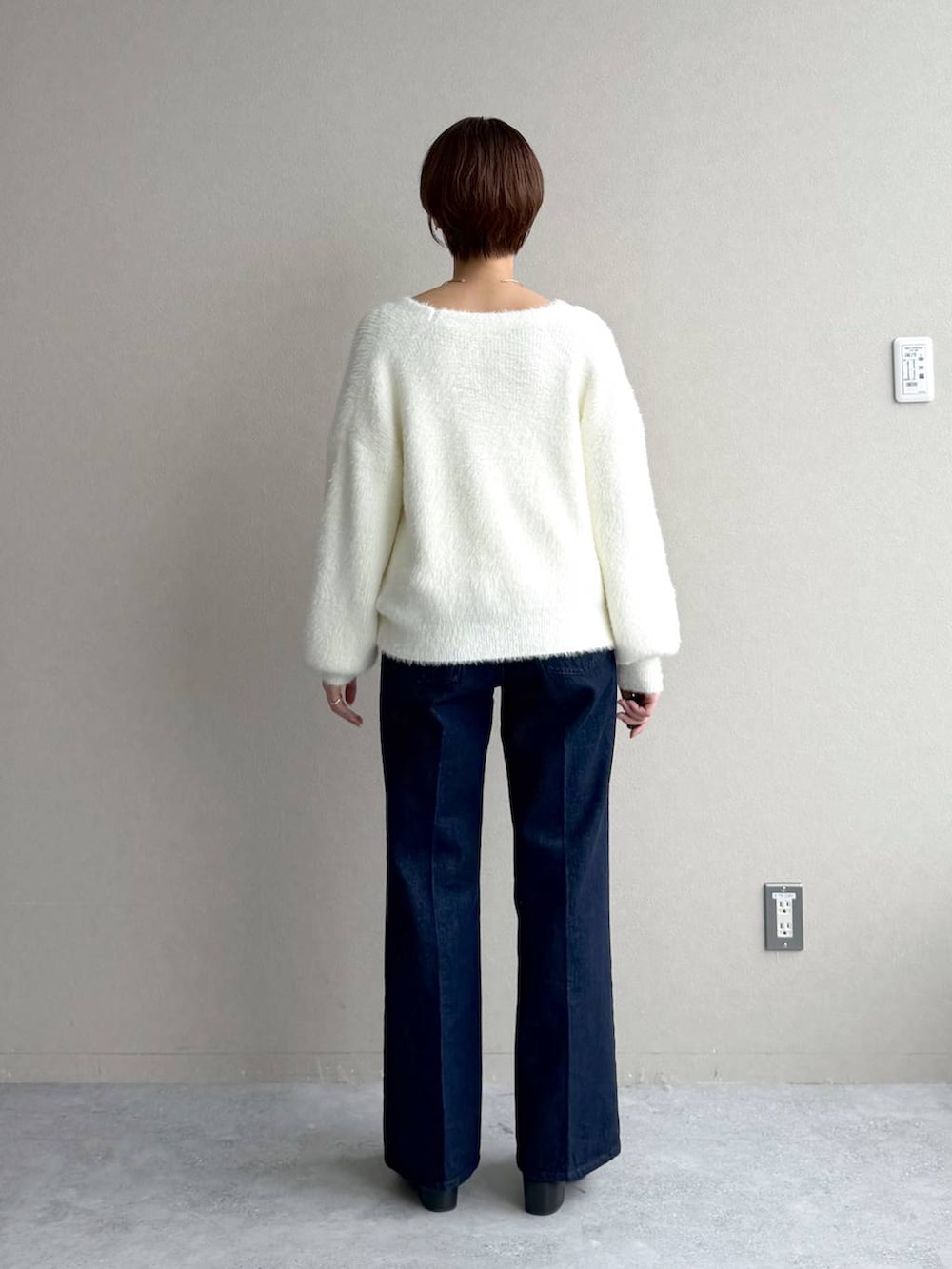 ブルー系のデニムパンツ、ホワイト系のカーディガン/ボレロ、ブラック系のボストンバッグを着用したレディースの秋コーディネートの7枚目の写真