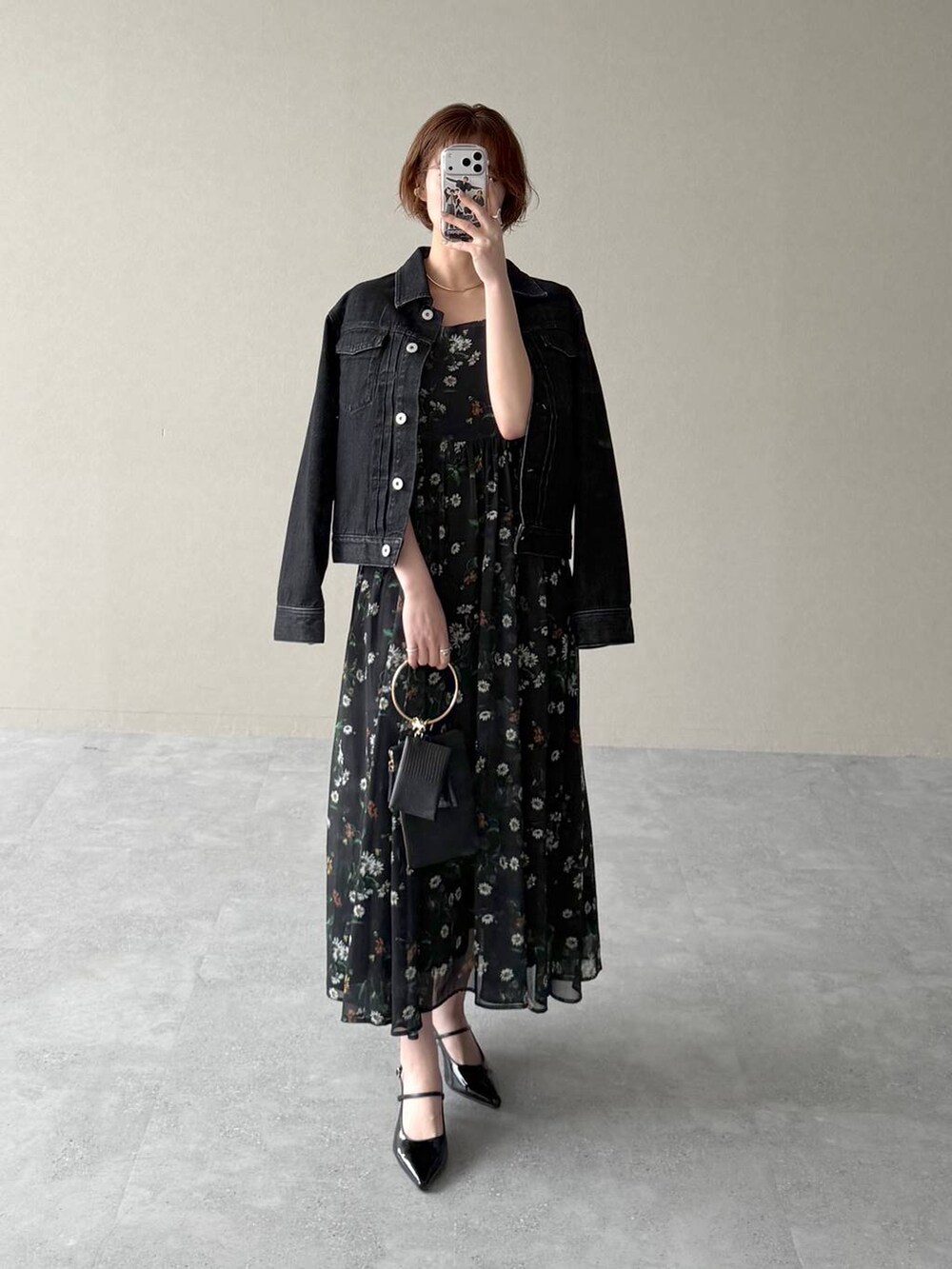 ブラック系のデニムジャケット、ブラック系のサンダル、ブラック系のショルダーバッグを着用したレディースの春コーディネートの4枚目の写真