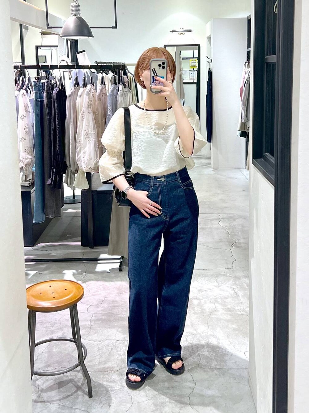 ブラック系のサンダル、ブルー系のデニムパンツ、ホワイト系のシャツ/ブラウスを着用したレディースの春コーディネートの4枚目の写真