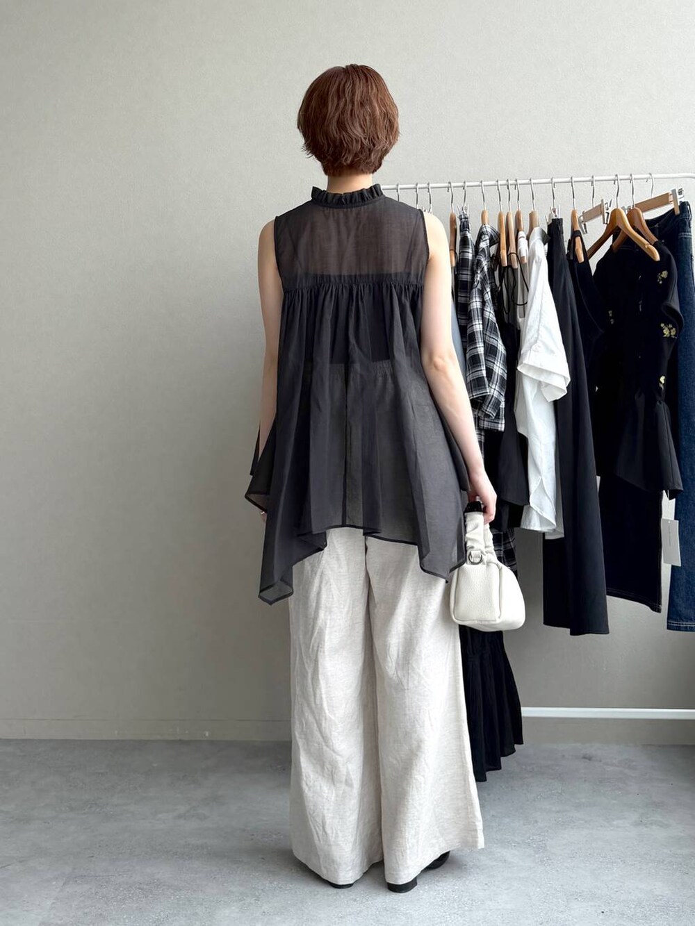 ブラック系のシャツ/ブラウス、ベージュ系のその他パンツ、ホワイト系のショルダーバッグを着用したレディースの夏コーディネートの3枚目の写真