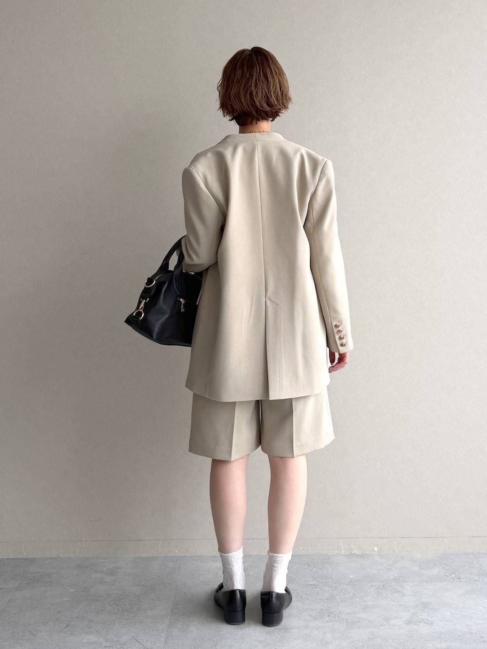 ブラック系のボストンバッグ、ブラック系のローファー、ベージュ系のその他パンツを着用したレディースの冬コーディネートの3枚目の写真