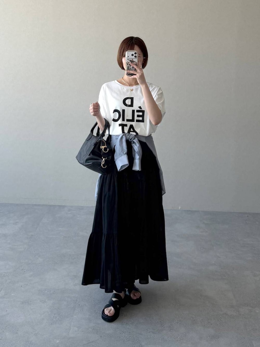 ブラック系のボストンバッグ、ブルー系のシャツ/ブラウス、ブラック系のサンダルを着用したレディースの春コーディネートの5枚目の写真