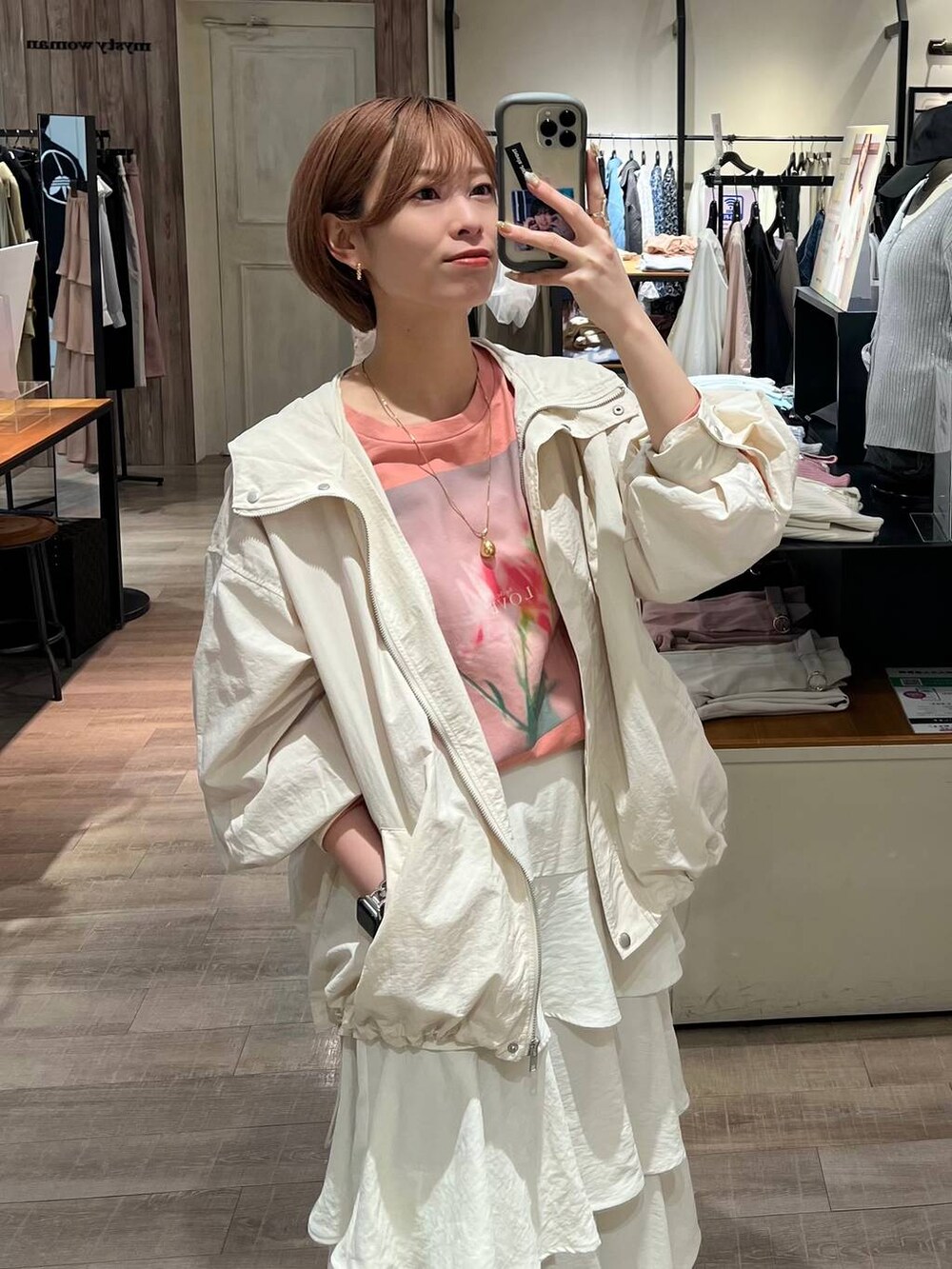 ホワイト系のスカート、ベージュ系のショルダーバッグ、ホワイト系のマウンテンパーカーを着用したレディースの春コーディネートの4枚目の写真