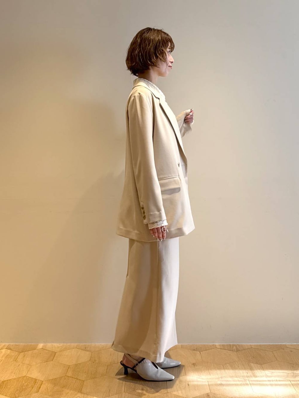 ホワイト系のサンダル、ベージュ系のテーラードジャケット、ベージュ系のスカートを着用したレディースの冬コーディネートの2枚目の写真