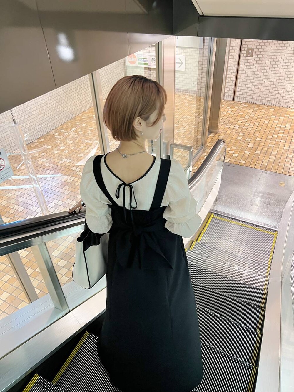 ブラック系のトートバッグ、ホワイト系のシャツ/ブラウス、ブラック系のパンプスを着用したレディースの春コーディネートの9枚目の写真