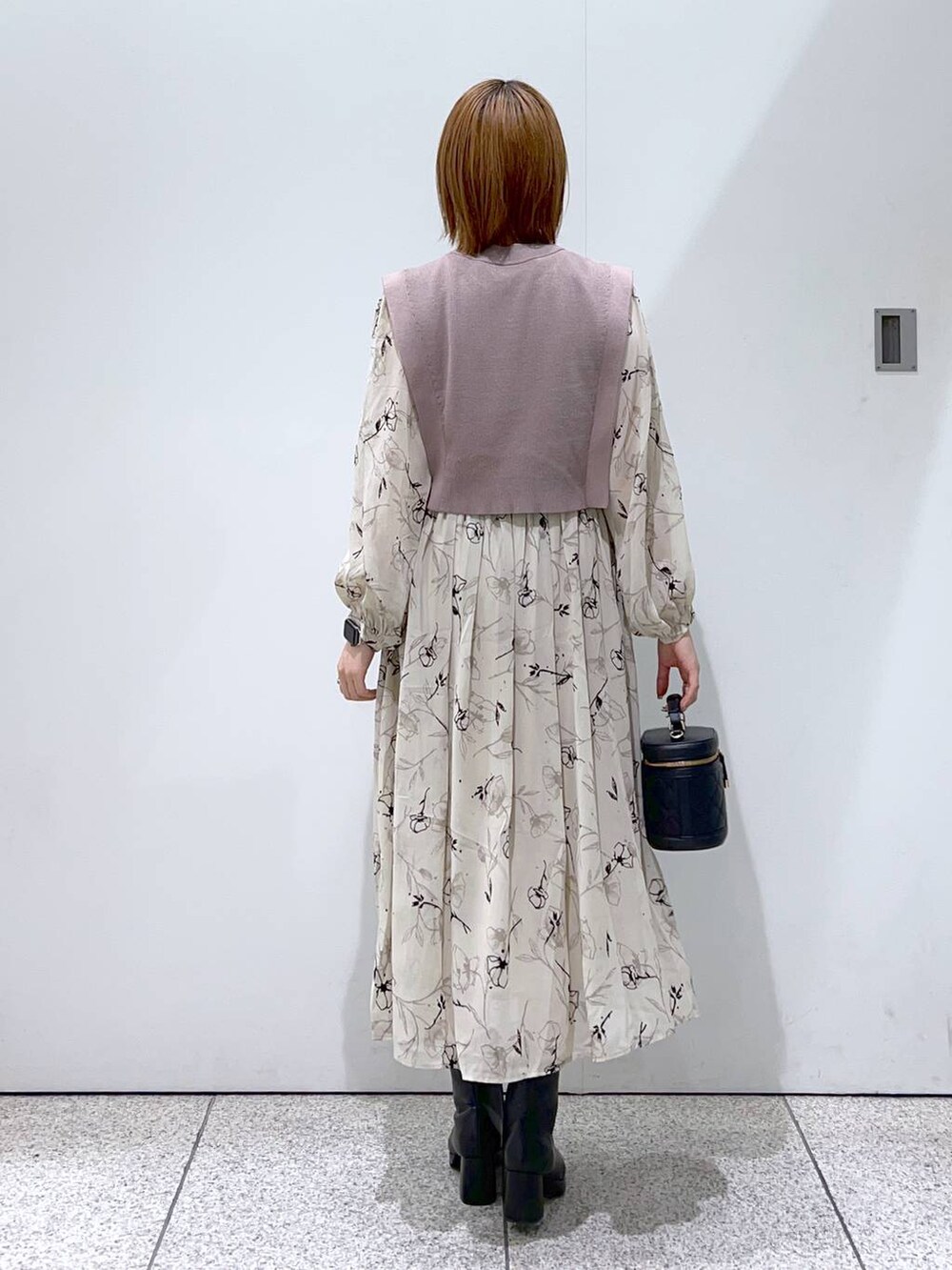 ブルー系のノーカラーコート、ブラック系のブーツ、ベージュ系のワンピースを着用したレディースの秋コーディネートの6枚目の写真