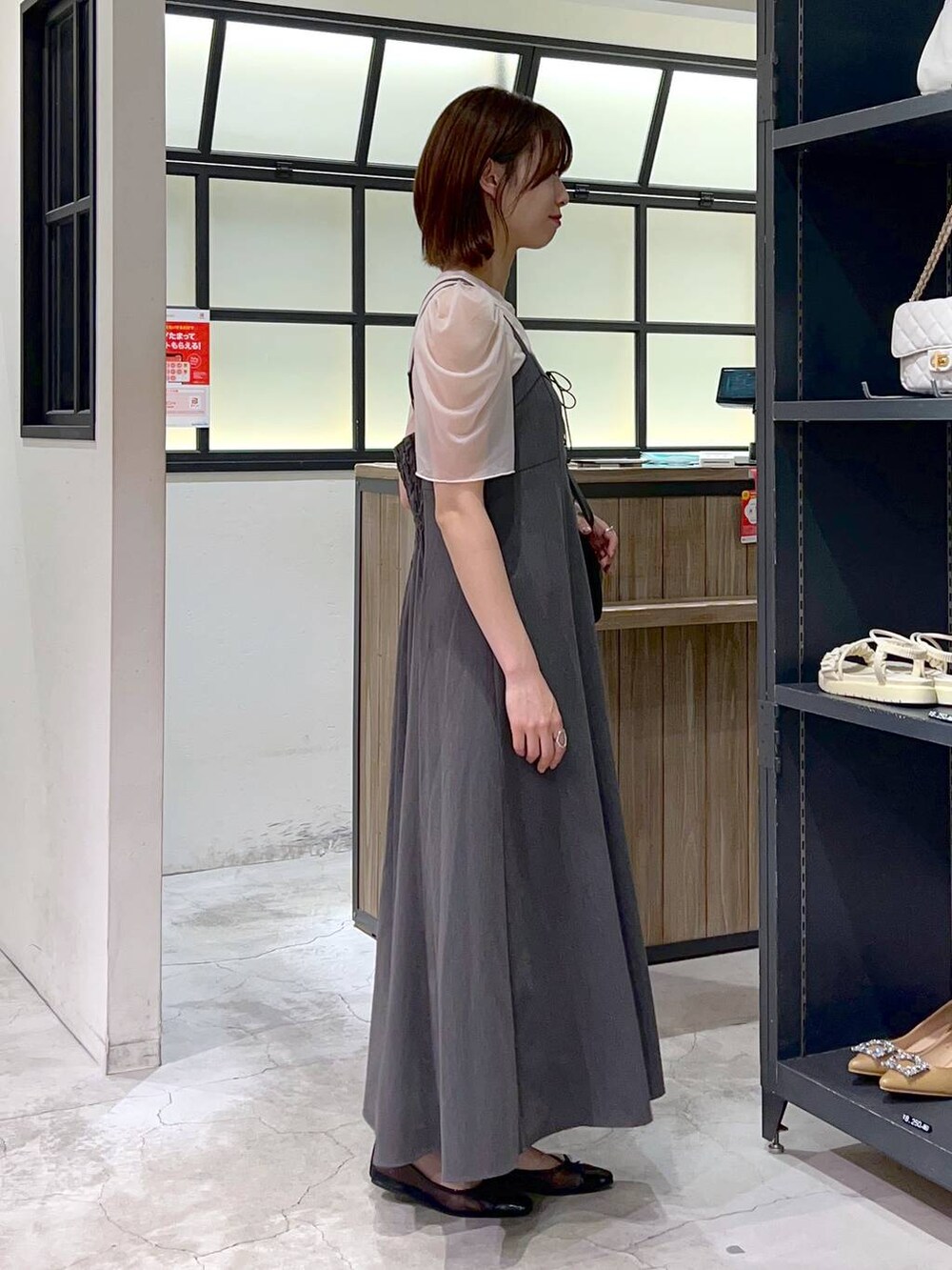 ブラック系のバレエシューズ、グレー系のワンピース、ホワイト系のTシャツ/カットソーを着用したレディースの春コーディネートの2枚目の写真