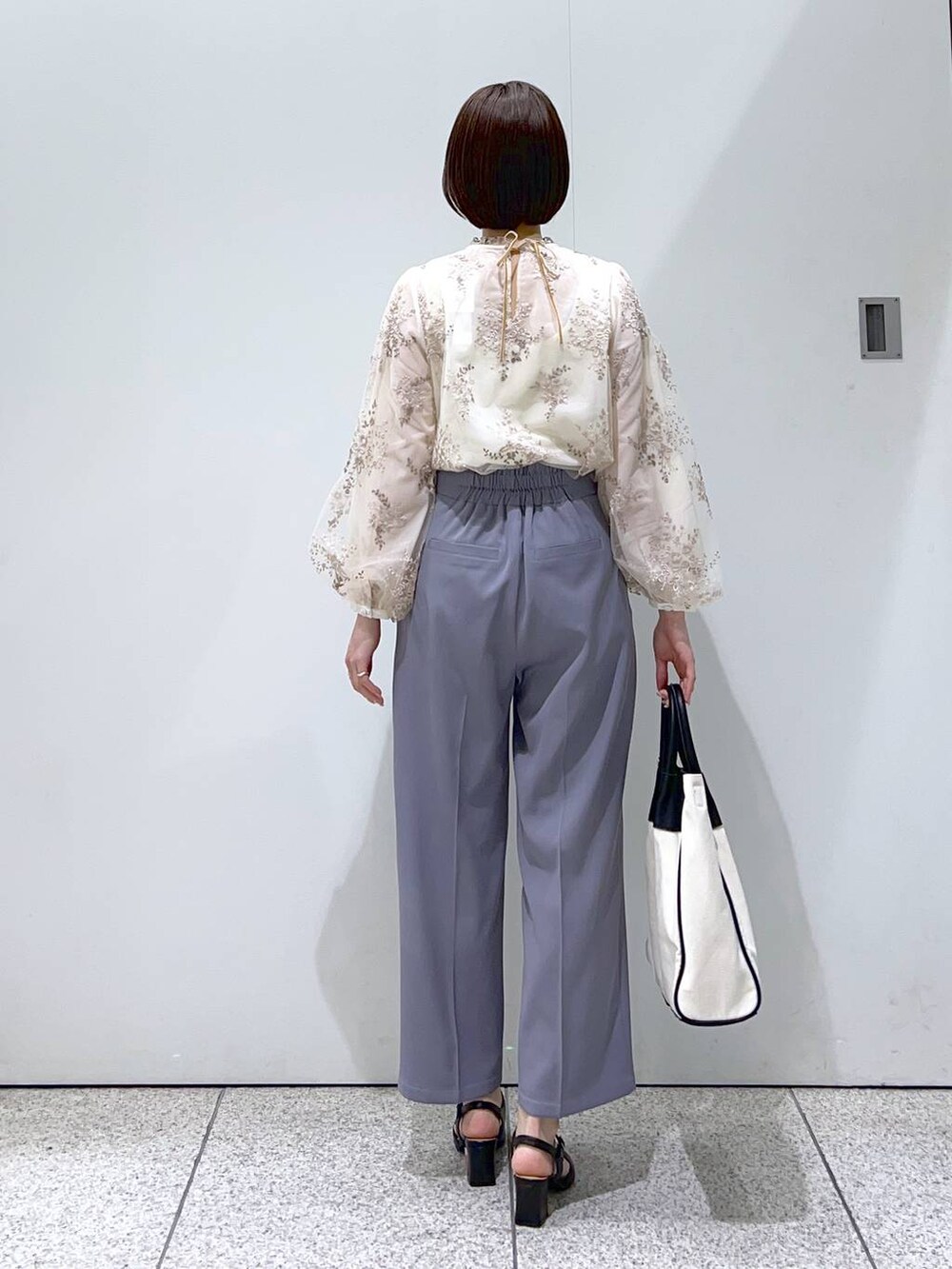 ブラック系のトートバッグ、ホワイト系のシャツ/ブラウス、ブラック系のパンプスを着用したレディースの冬コーディネートの6枚目の写真