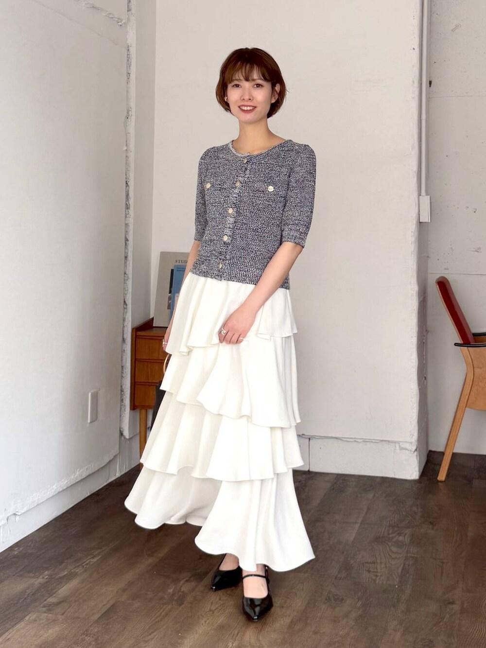 ホワイト系のスカート、ブラック系のサンダル、ブラック系のショルダーバッグを着用したレディースの春コーディネートの4枚目の写真