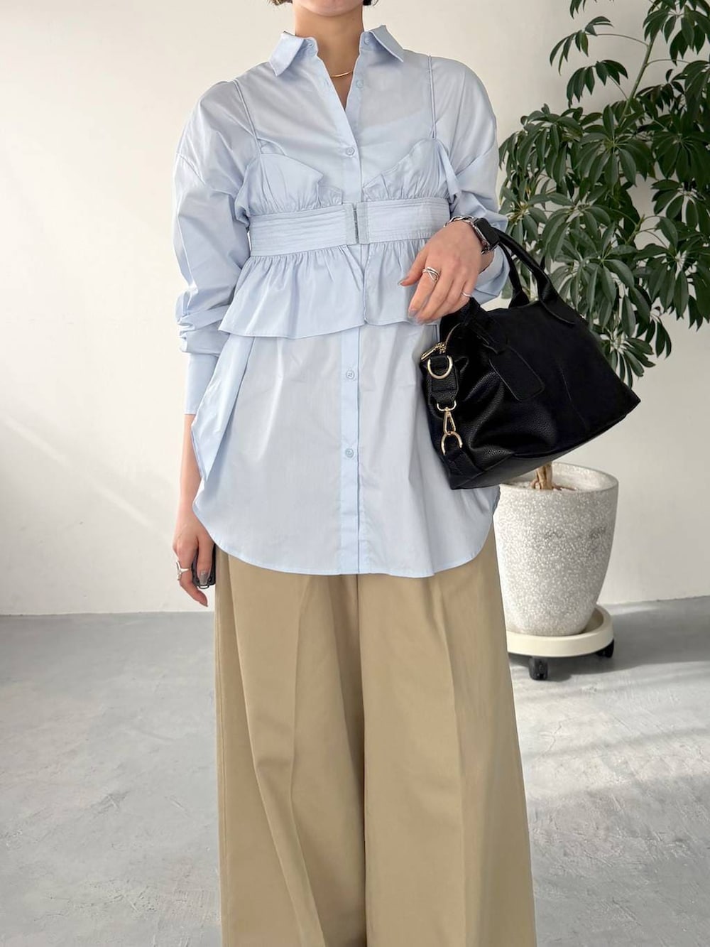 ブラック系のボストンバッグ、ブルー系のシャツ/ブラウス、ベージュ系のチノパンツを着用したレディースの春コーディネートの4枚目の写真