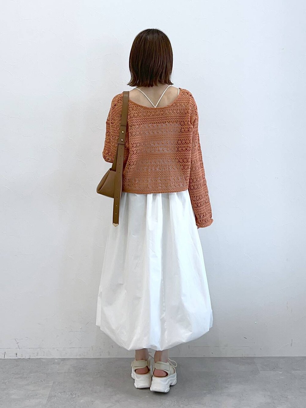 ホワイト系のサンダル、オレンジ系のカーディガン/ボレロ、ホワイト系のキャミソールを着用したレディースの春コーディネートの3枚目の写真