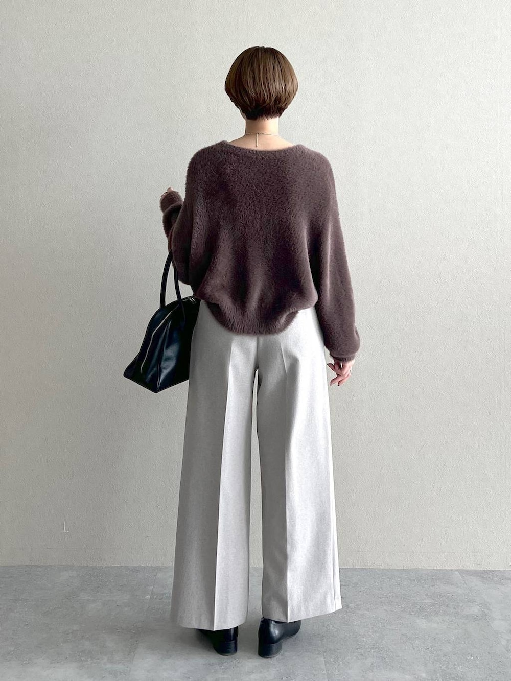 ブラック系のローファー、ブラック系のトートバッグ、ブラウン系のニット/セーターを着用したレディースの秋コーディネートの3枚目の写真