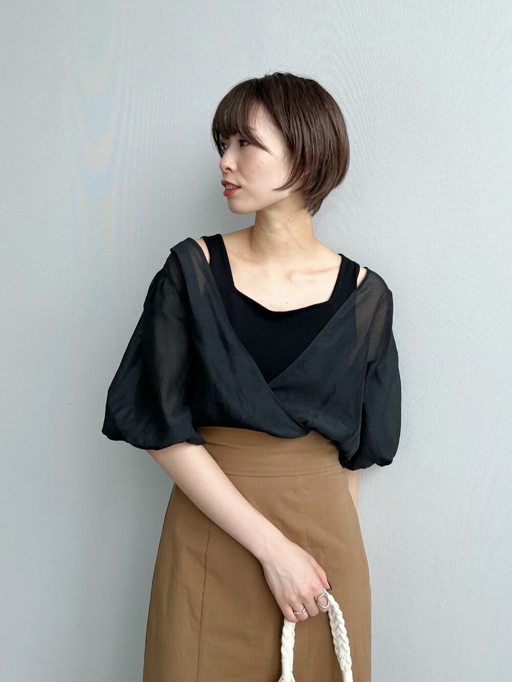 ブラック系のTシャツ/カットソー、ブラウン系のスカート、ホワイト系のトートバッグを着用したレディースの夏コーディネートの2枚目の写真