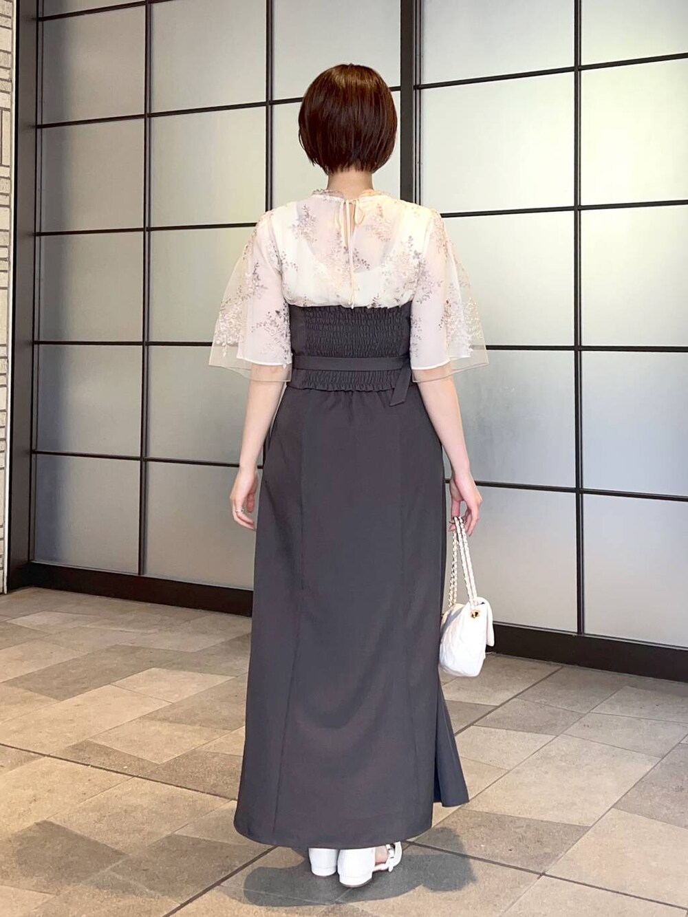 ホワイト系のシャツ/ブラウス、ホワイト系のショルダーバッグ、ホワイト系のパンプスを着用したレディースの夏コーディネートの3枚目の写真