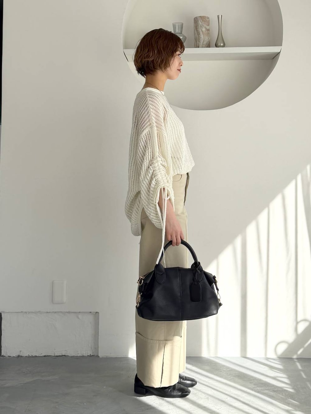 ブラック系のボストンバッグ、ブラック系のローファー、ブラック系のMA-1を着用したレディースの冬コーディネートの6枚目の写真