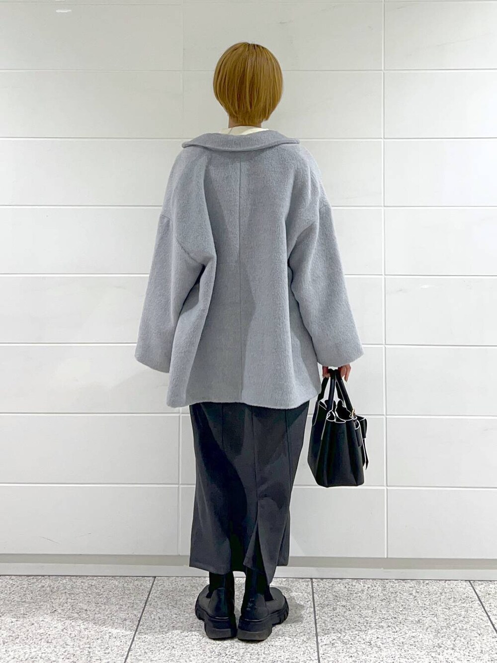 ブラック系のブーツ、ホワイト系のニット/セーター、ブラック系のショルダーバッグを着用したレディースの冬コーディネートの3枚目の写真