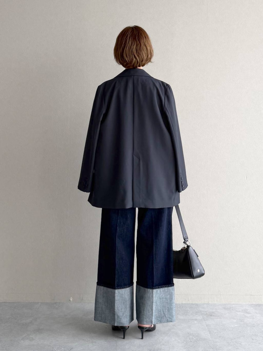 ブラック系のサンダル、ブルー系のシャツ/ブラウス、ブラック系のショルダーバッグを着用したレディースの春コーディネートの3枚目の写真