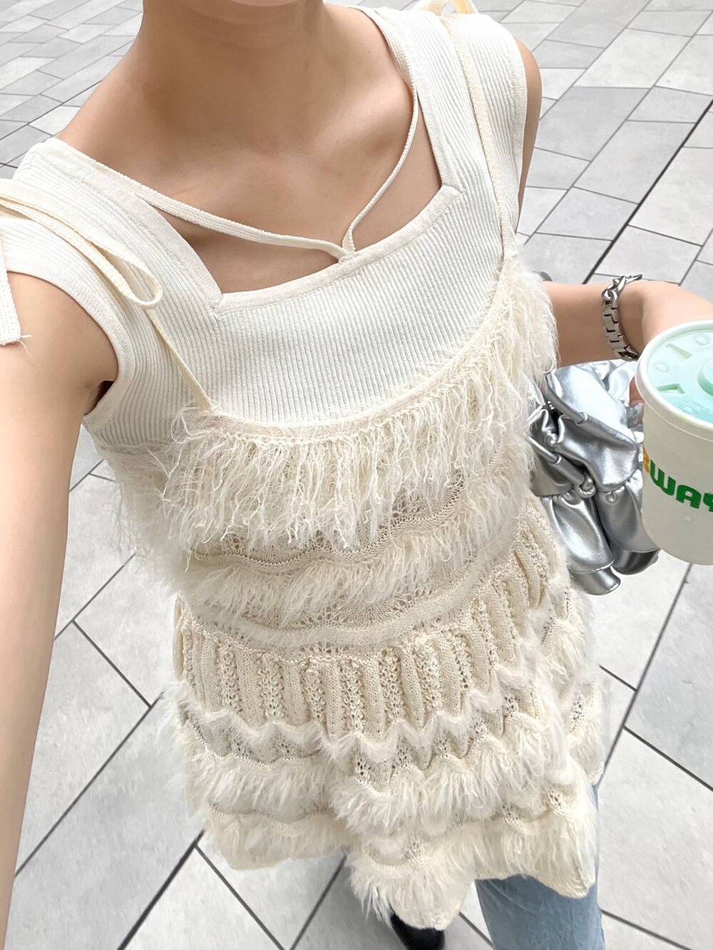 ブルー系のデニムパンツ、ホワイト系のキャミソール、ホワイト系のニット/セーターを着用したレディースの秋コーディネートの6枚目の写真