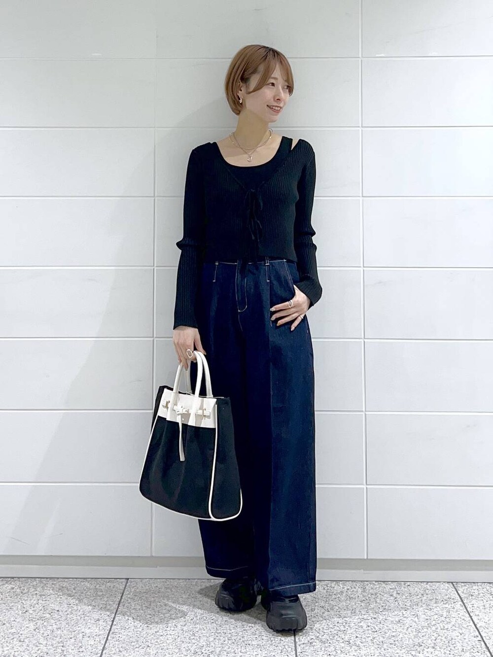 ブラック系のトートバッグ、グリーン系のマウンテンパーカー、ブラック系のバレエシューズを着用したレディースの春コーディネートの4枚目の写真