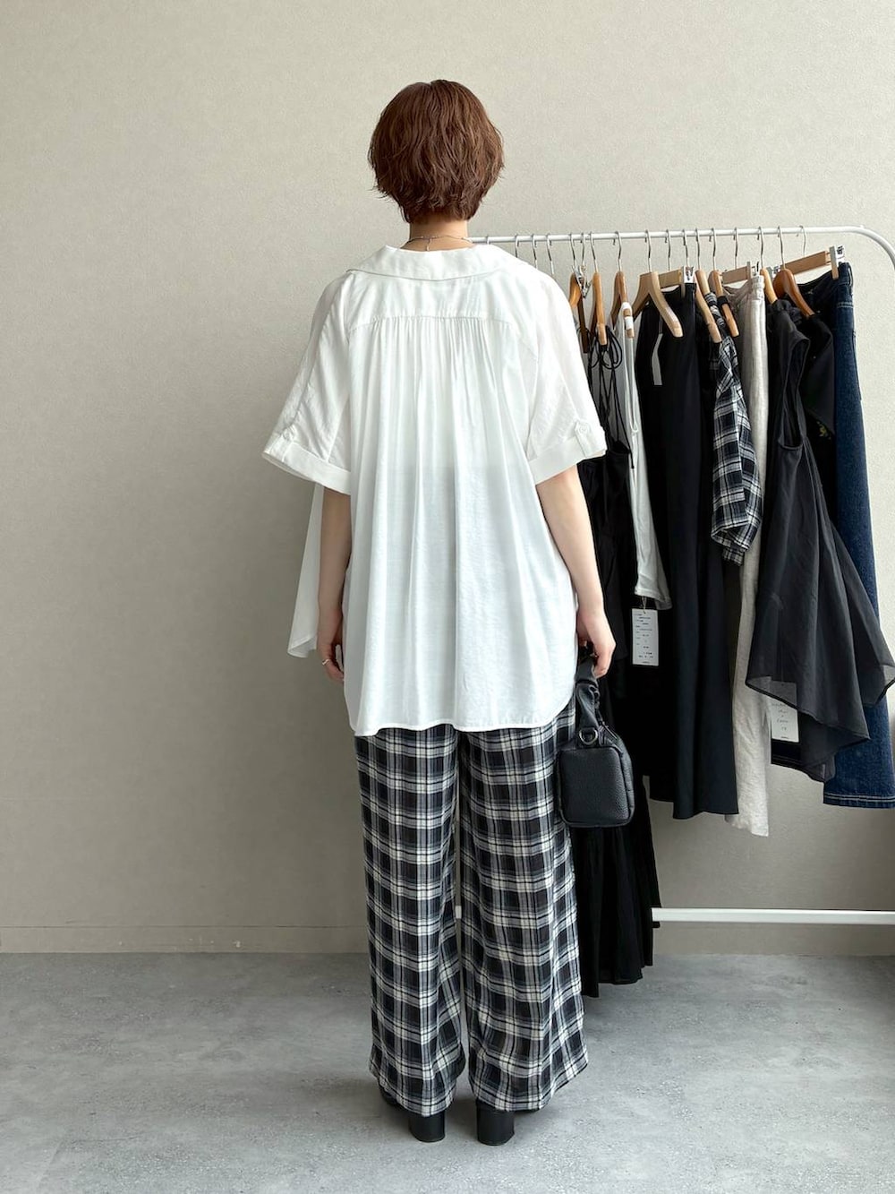 ブラック系のその他パンツ、ブラック系のショルダーバッグ、ホワイト系のシャツ/ブラウスを着用したレディースの夏コーディネートの3枚目の写真
