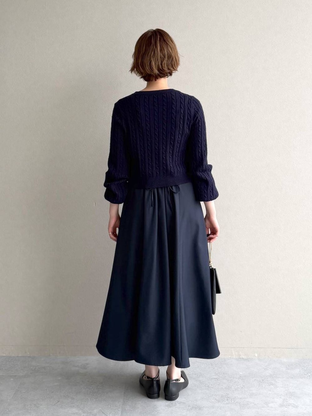 ブルー系のワンピース、ブラック系のパンプス、ブラック系のショルダーバッグを着用したレディースの冬コーディネートの3枚目の写真