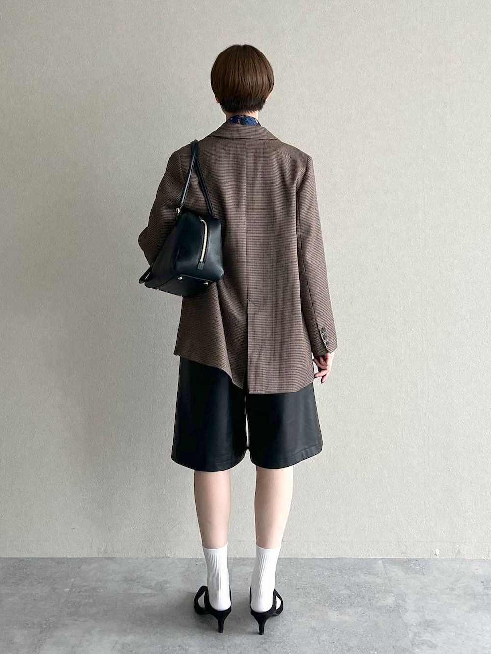 ブラック系のハンドバッグ、ブラック系のその他パンツ、ブラウン系のテーラードジャケットを着用したレディースの秋コーディネートの3枚目の写真