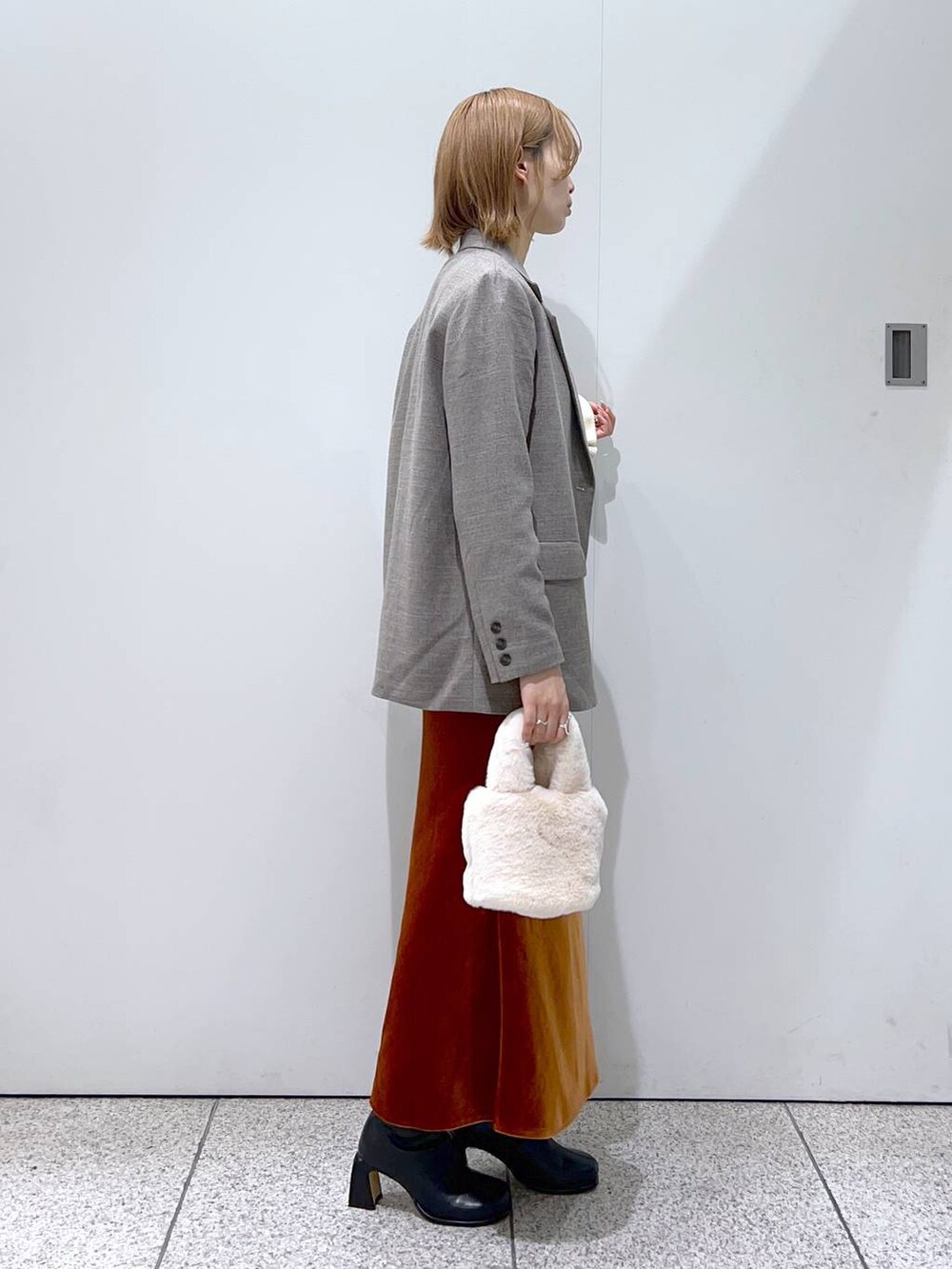 ホワイト系のTシャツ/カットソー、ブラック系のブーツ、グレー系のテーラードジャケットを着用したレディースの秋コーディネートの2枚目の写真