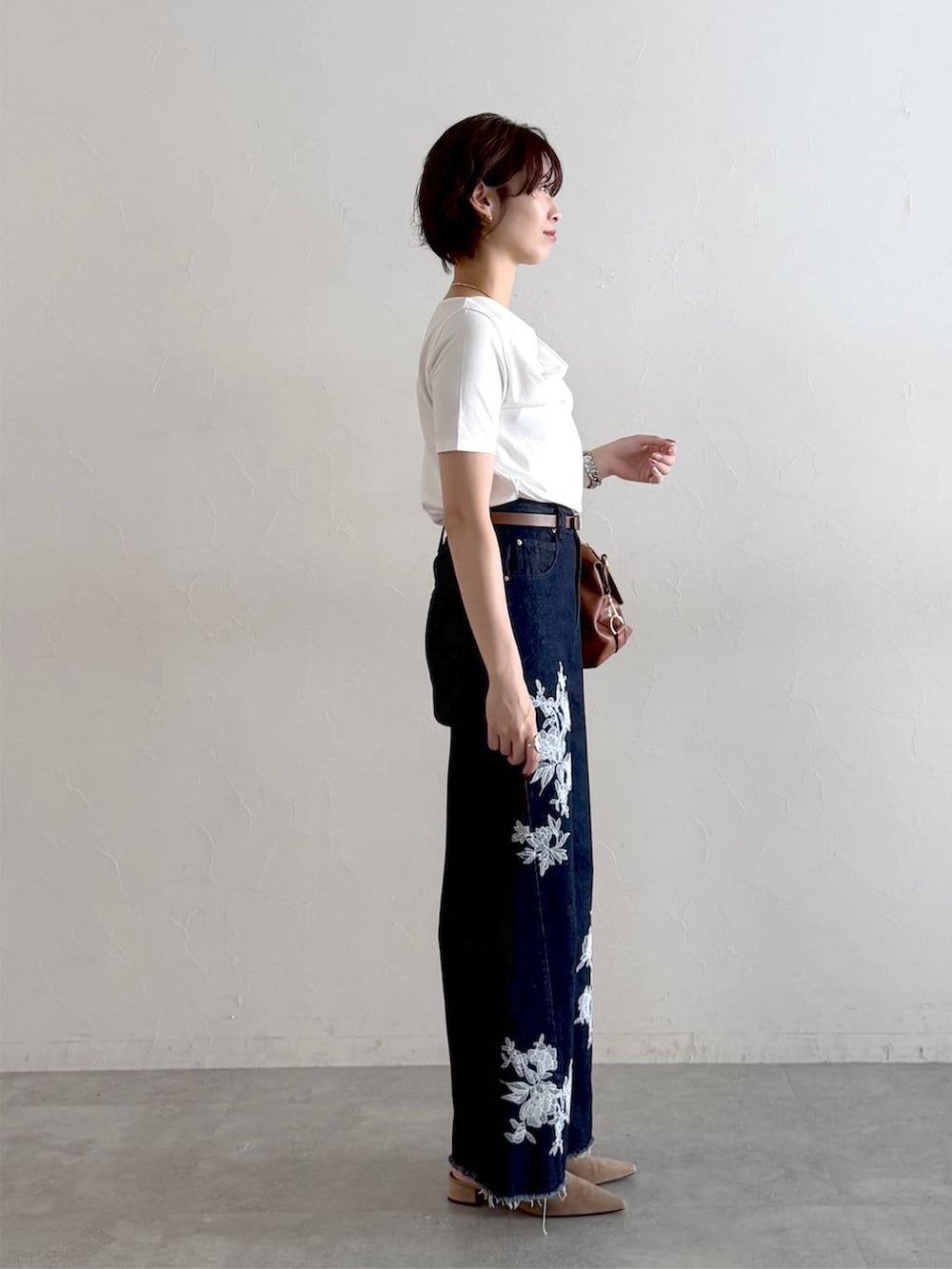 ベージュ系のサンダル、ホワイト系のTシャツ/カットソー、ブルー系のデニムパンツを着用したレディースの夏コーディネートの2枚目の写真