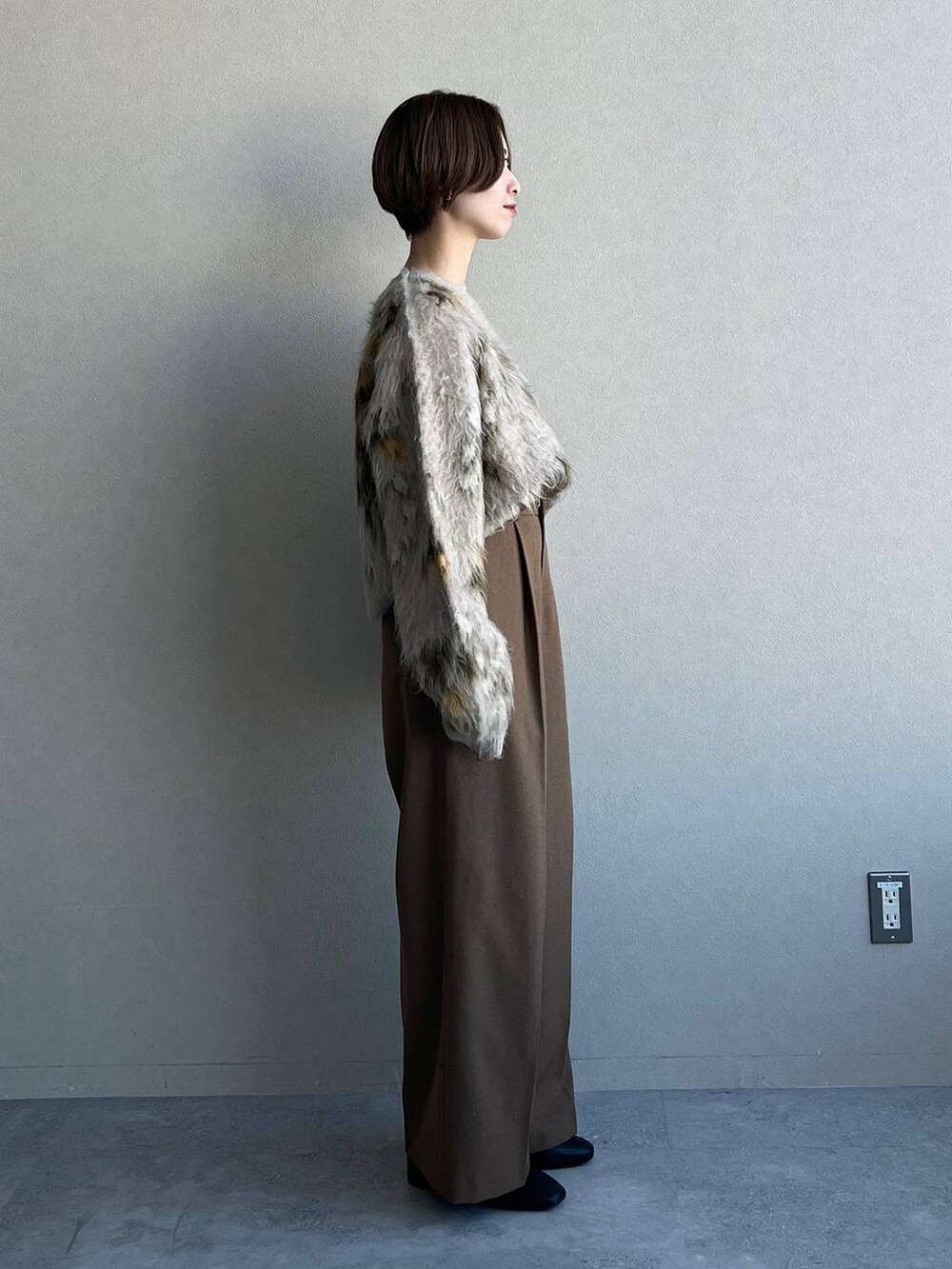 ベージュ系のニット/セーター、ブラック系のブーツ、ブラウン系のスラックスを着用したレディースの冬コーディネートの2枚目の写真